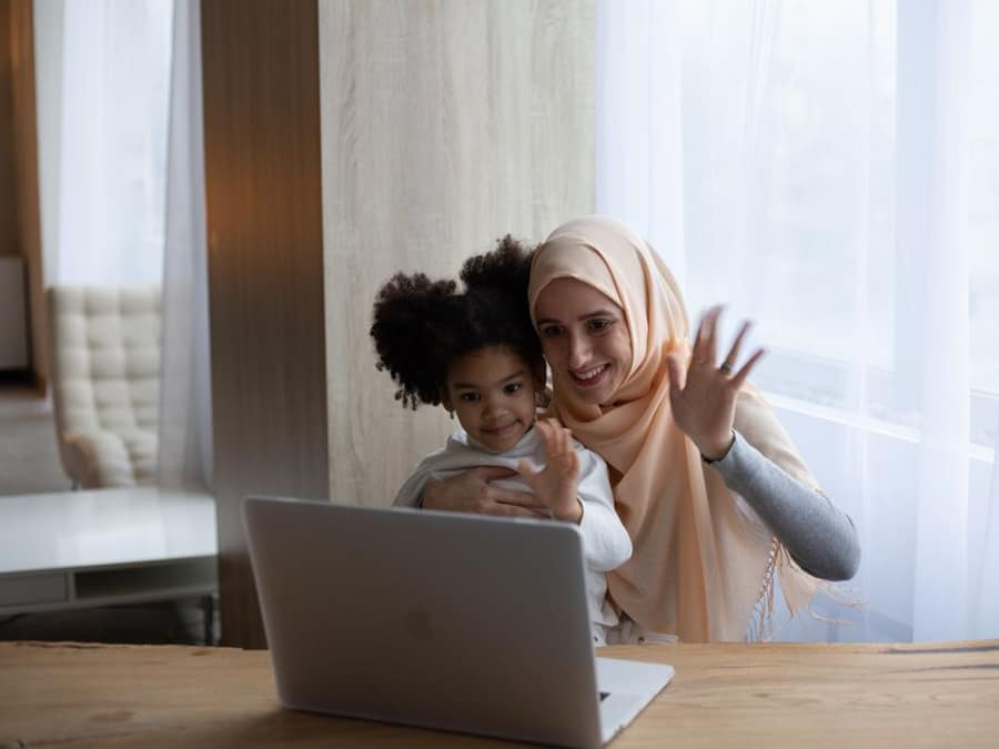 A mother and her daughter waving during a WAYA video call